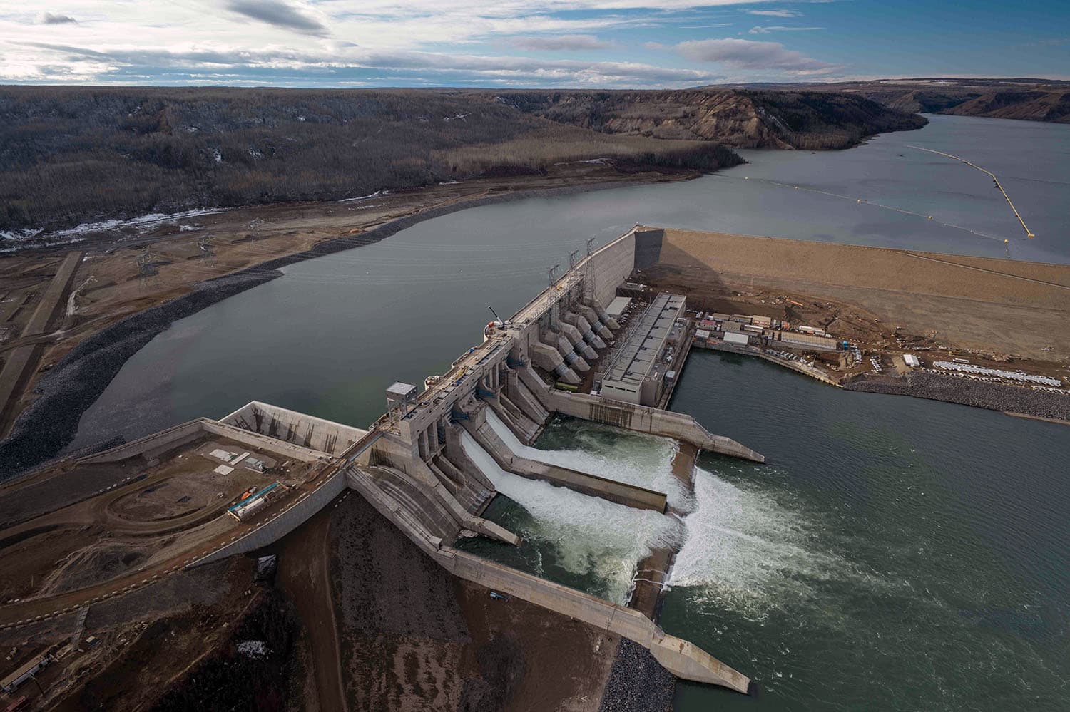 Hydroelectric facility framed by evergreen forest representing renewable energy infrastructure